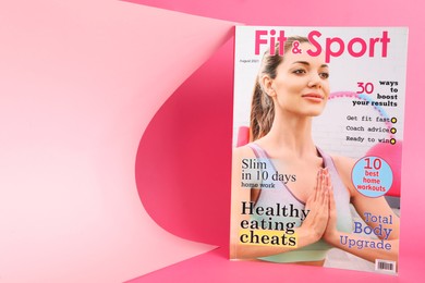 Photo of Modern printed sports magazine on pink background, space for text