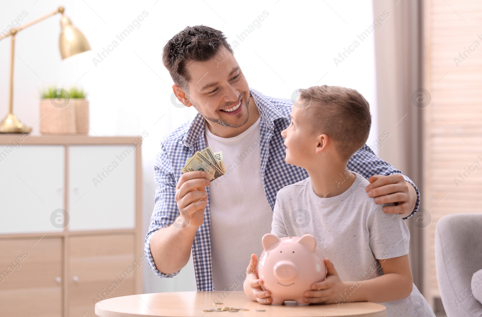 Photo of Family with piggy bank and money at home