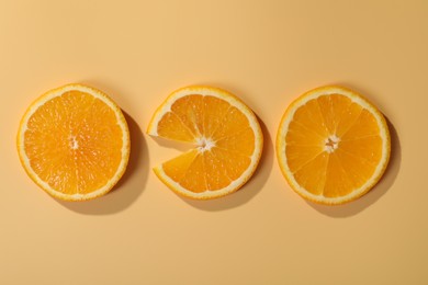 Slices of juicy orange on beige background, flat lay