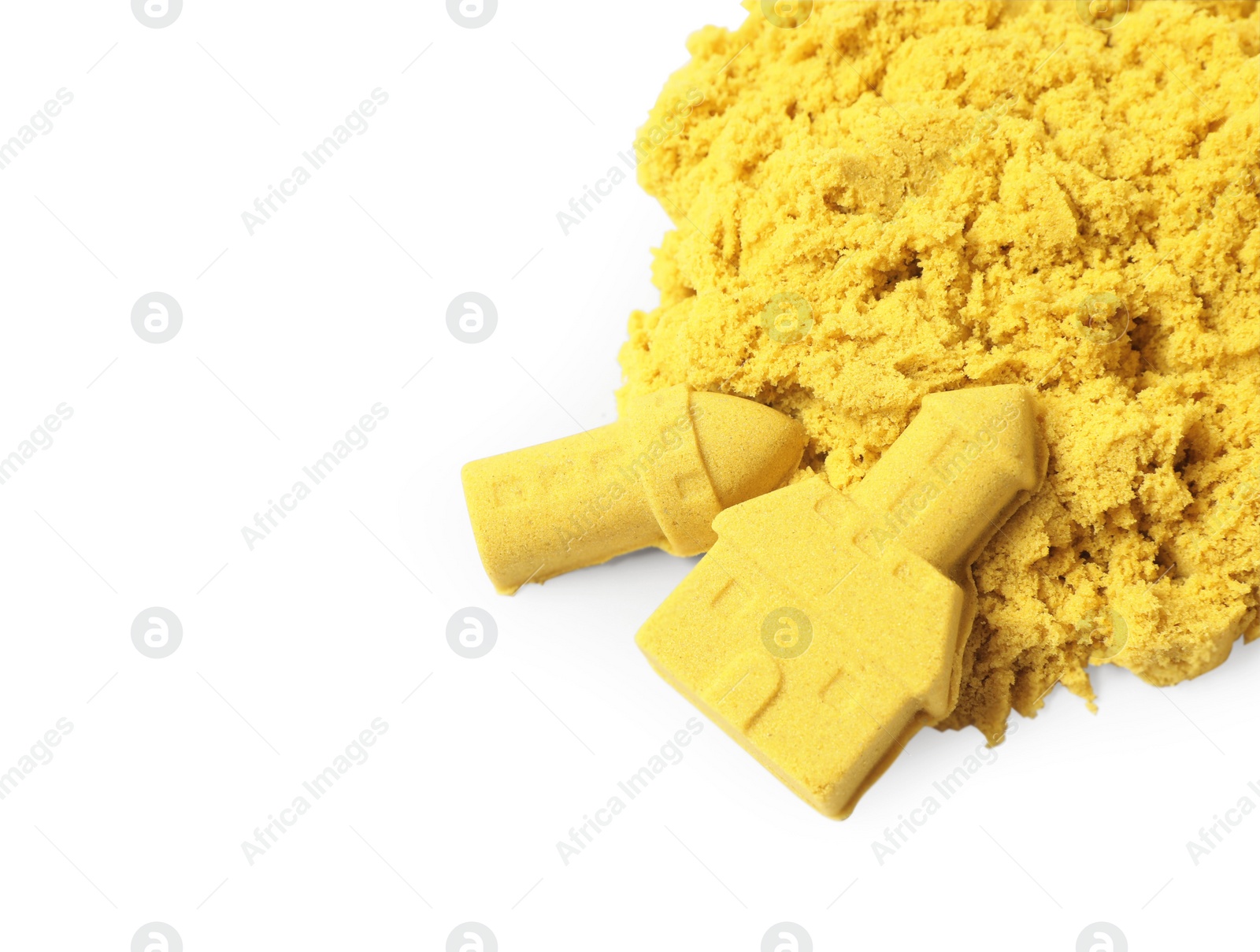 Photo of Castle and tower made of yellow kinetic sand isolated on white