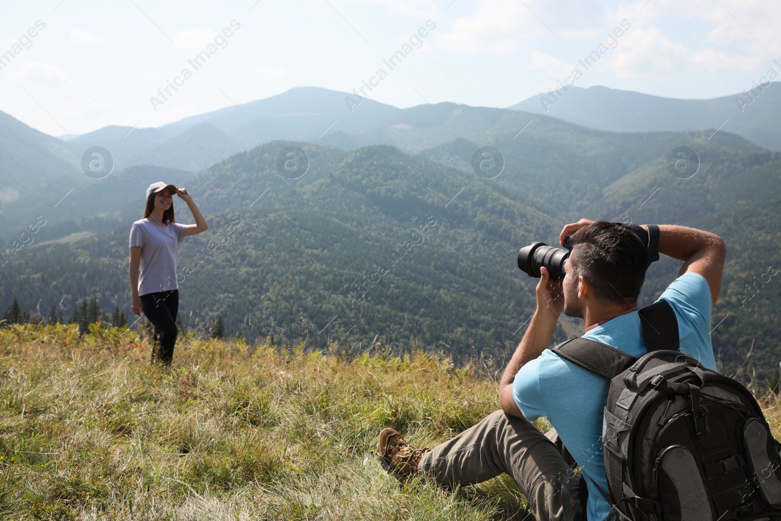 Photo of Professional photographer taking picture of woman in mountains