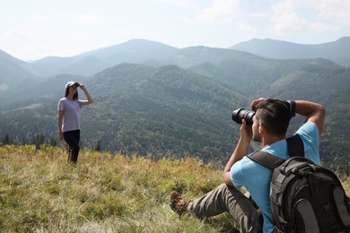 Photo of Professional photographer taking picture of woman in mountains