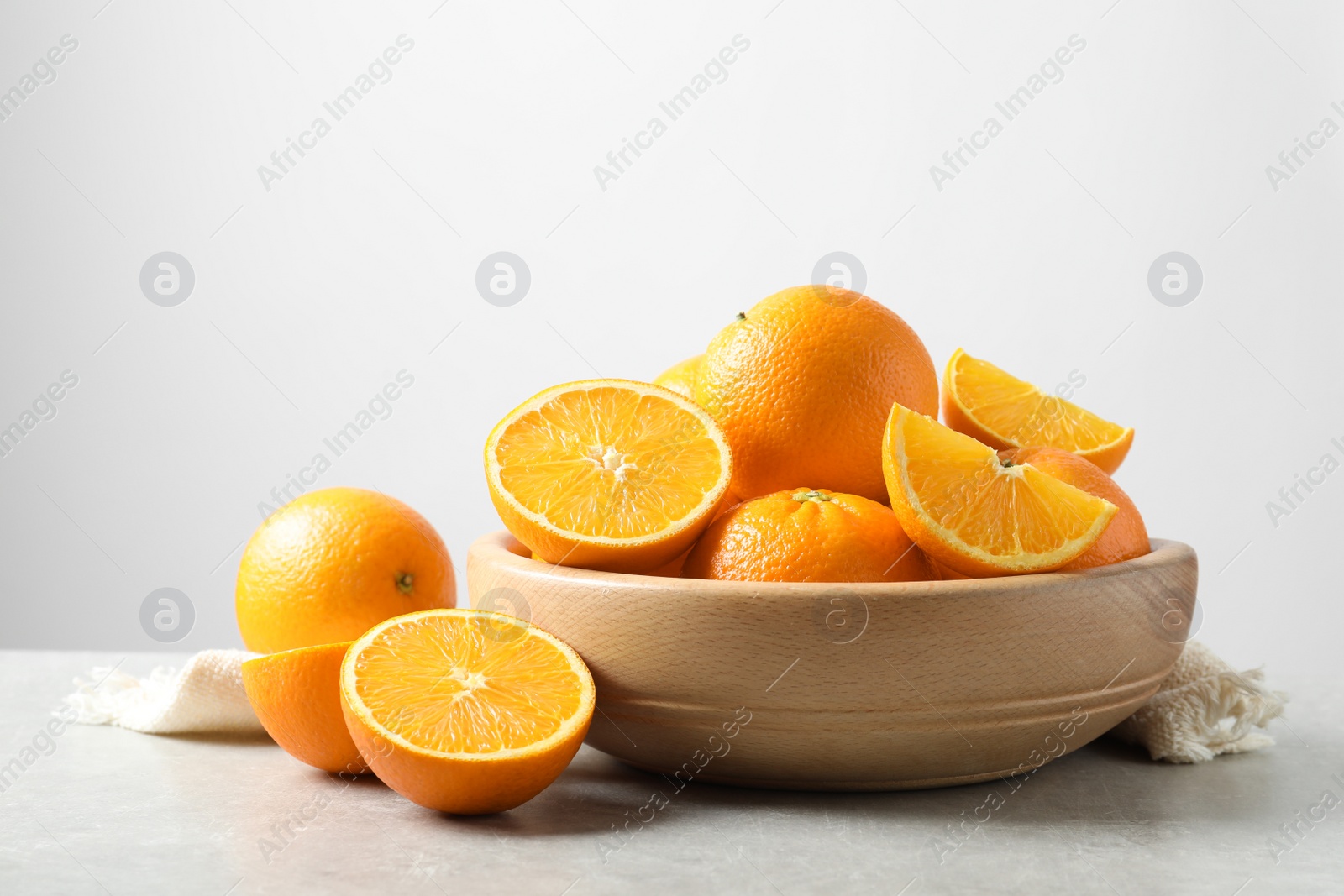 Photo of Composition with ripe oranges on table against light background. Space for text