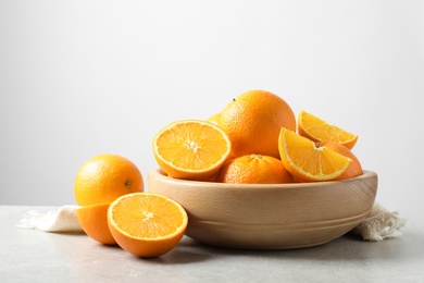 Photo of Composition with ripe oranges on table against light background. Space for text