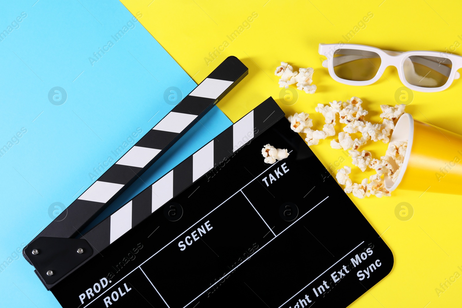 Photo of Clapperboard, popcorn and 3D glasses on color background, flat lay