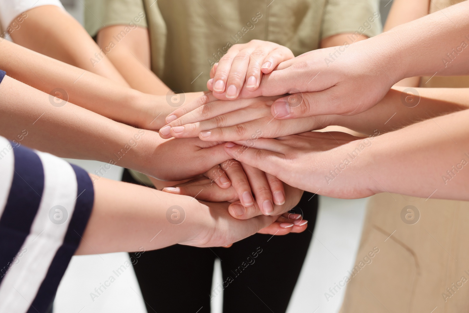 Photo of Group of people holding hands together indoors, closeup. Unity concept