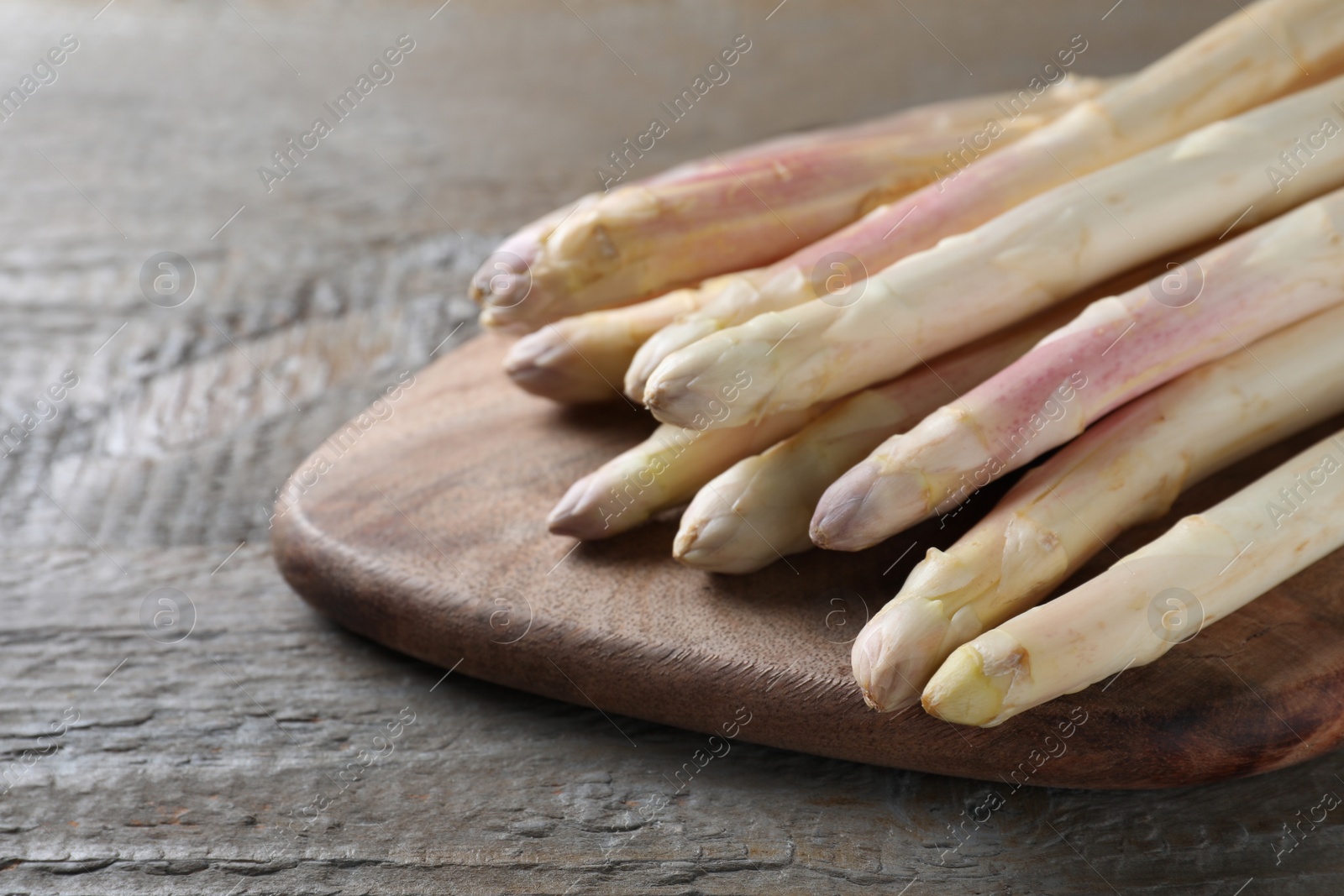 Photo of Fresh white asparagus on wooden table, closeup