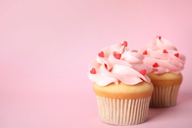 Photo of Tasty cupcakes with heart shaped sprinkles on pink background, space for text. Valentine's Day celebration