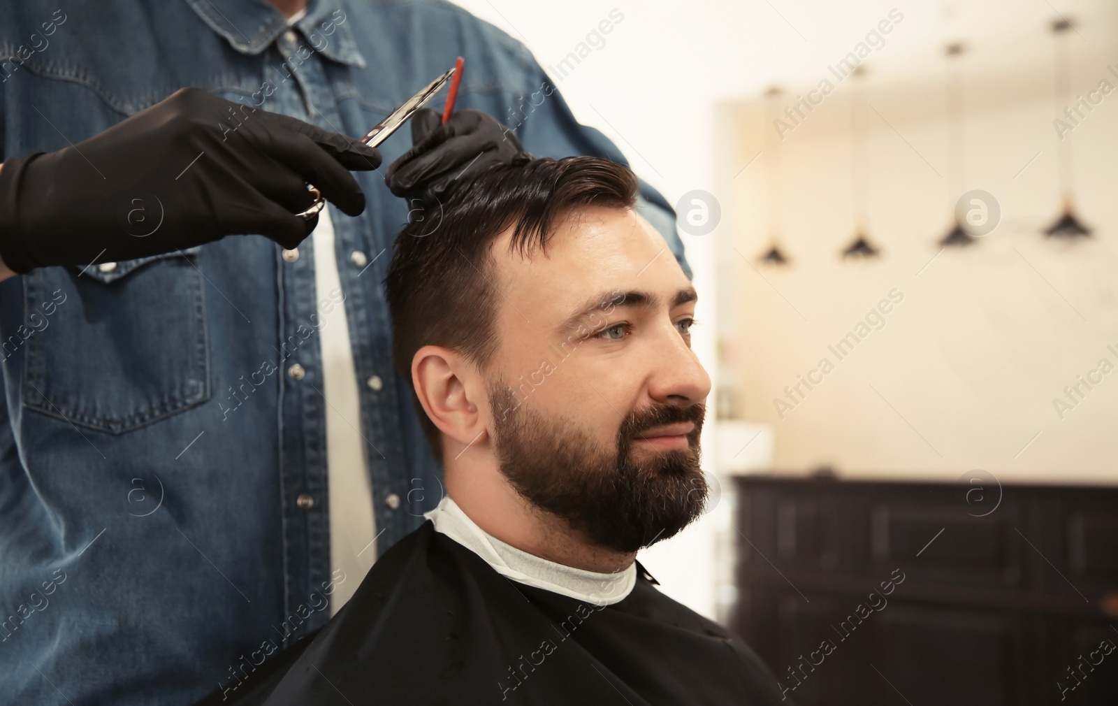 Photo of Professional barber working with client in hairdressing salon. Hipster fashion