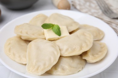 Photo of Delicious dumplings (varenyky) with tasty filling and butter on table, closeup