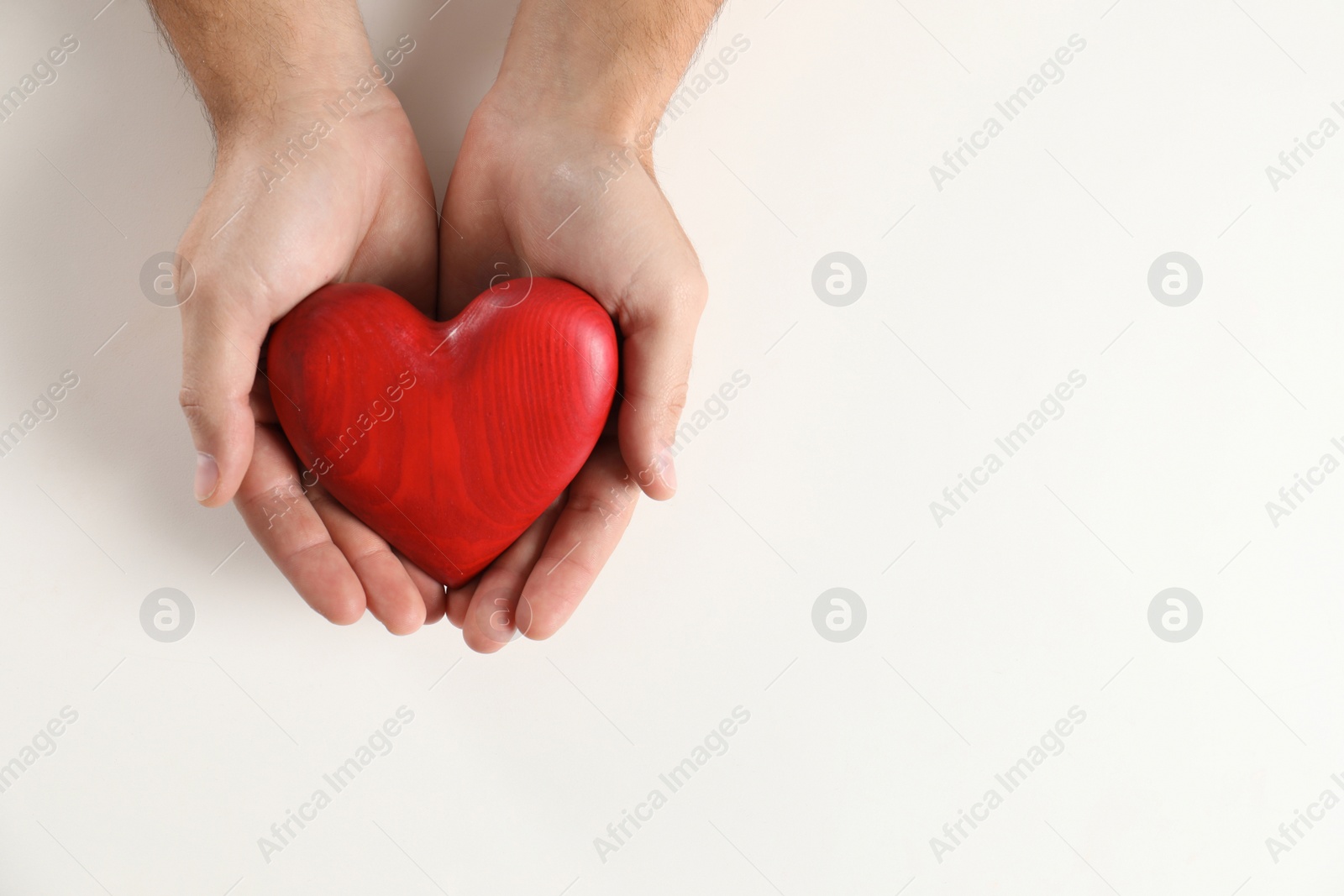 Photo of Man holding decorative heart on white background, top view with space for text