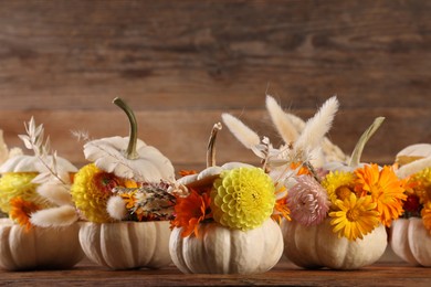 Photo of Composition with small pumpkins, beautiful flowers and spikelets on wooden table