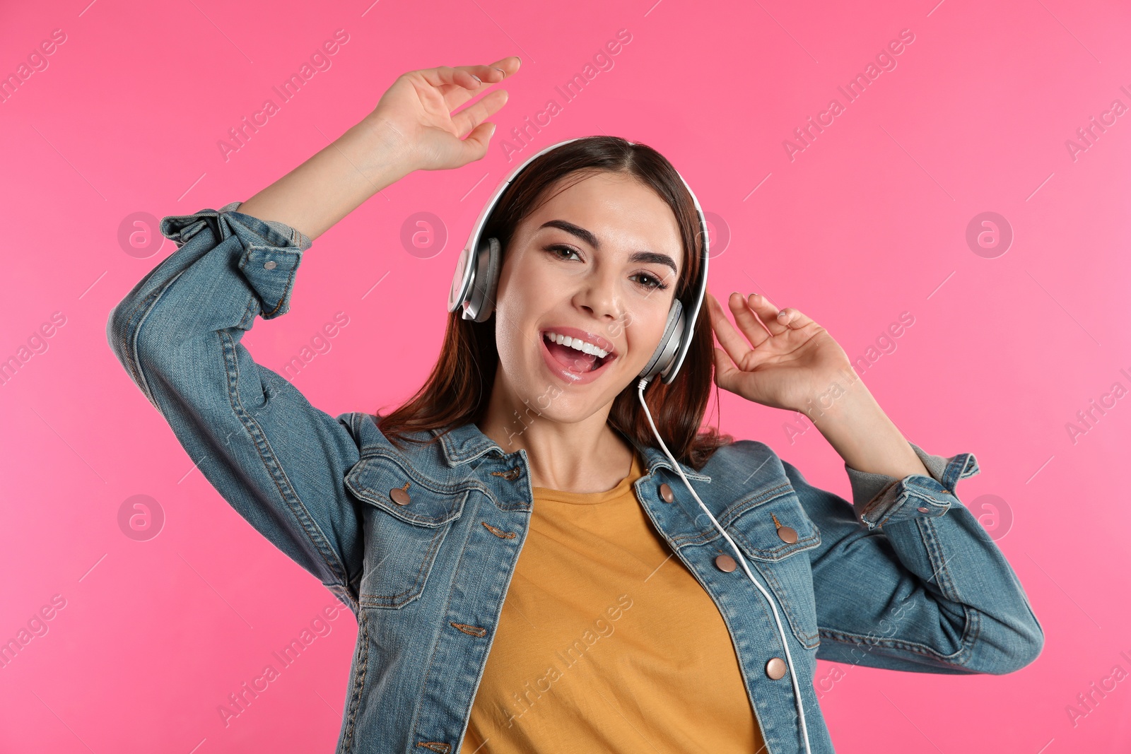 Photo of Beautiful young woman listening to music with headphones on color background