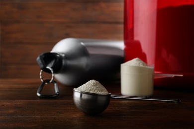 Photo of Measuring scoop of protein powder on wooden table