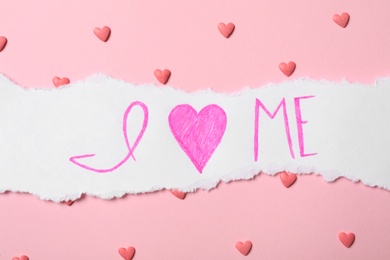 Photo of Piece of paper with phrase I Love Me and heart shaped sprinkles on pink background, flat lay
