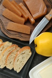 Photo of Delicious quince paste, bread, butter and fresh fruit on grey table, flat lay