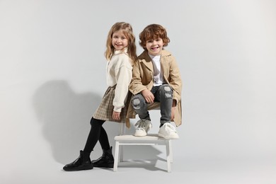 Fashion concept. Stylish children posing on light grey background