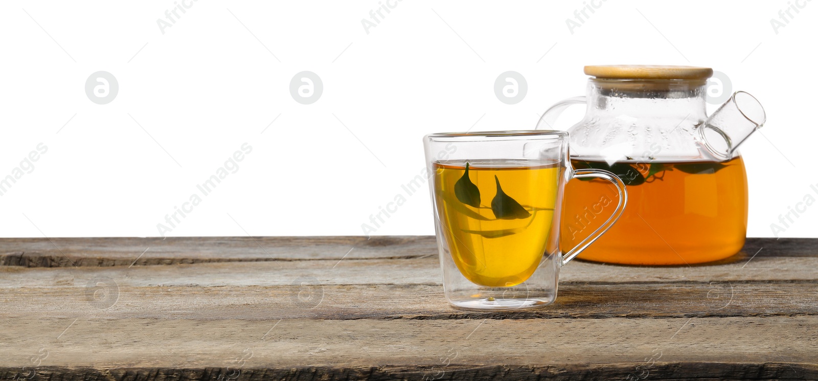 Photo of Refreshing green tea in cup and teapot on wooden table against white background