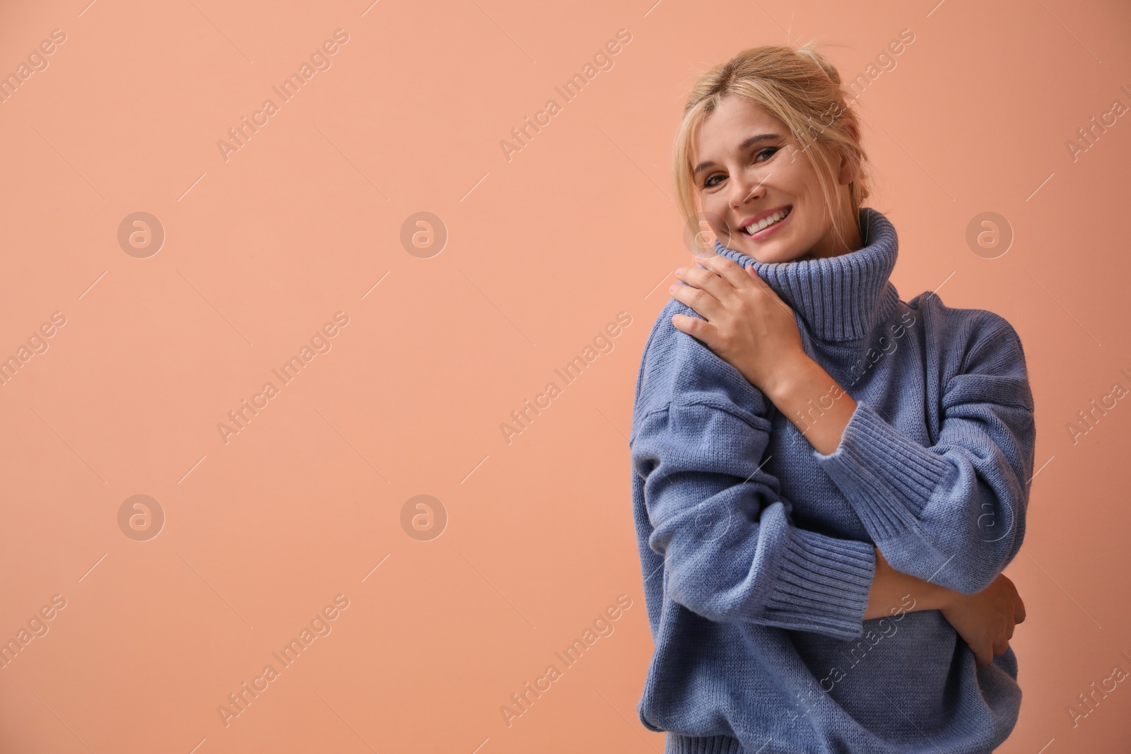 Photo of Happy woman in stylish sweater on color background. Space for text