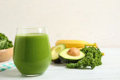 Photo of Tasty fresh kale smoothie on white wooden table