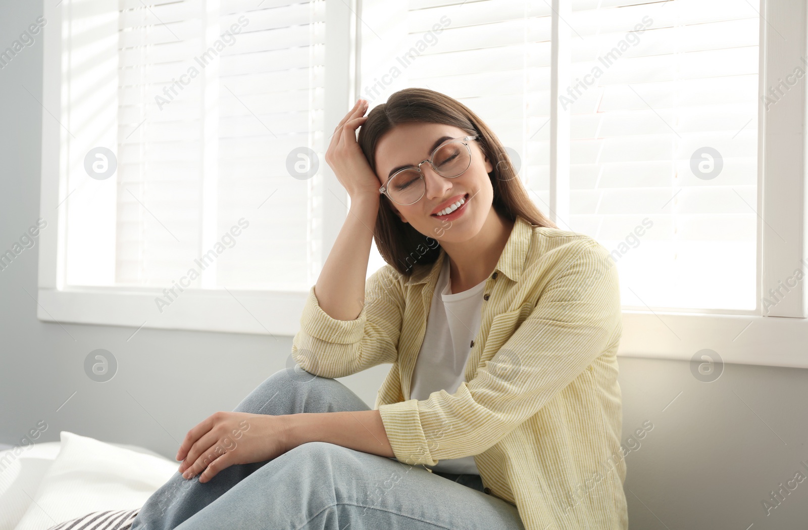 Photo of Beautiful young woman near window at home