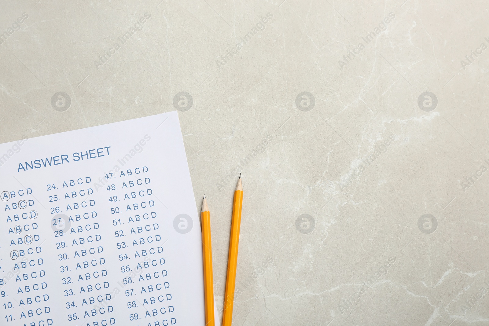 Photo of Answer sheet and pencils on grey background, top view with space for text