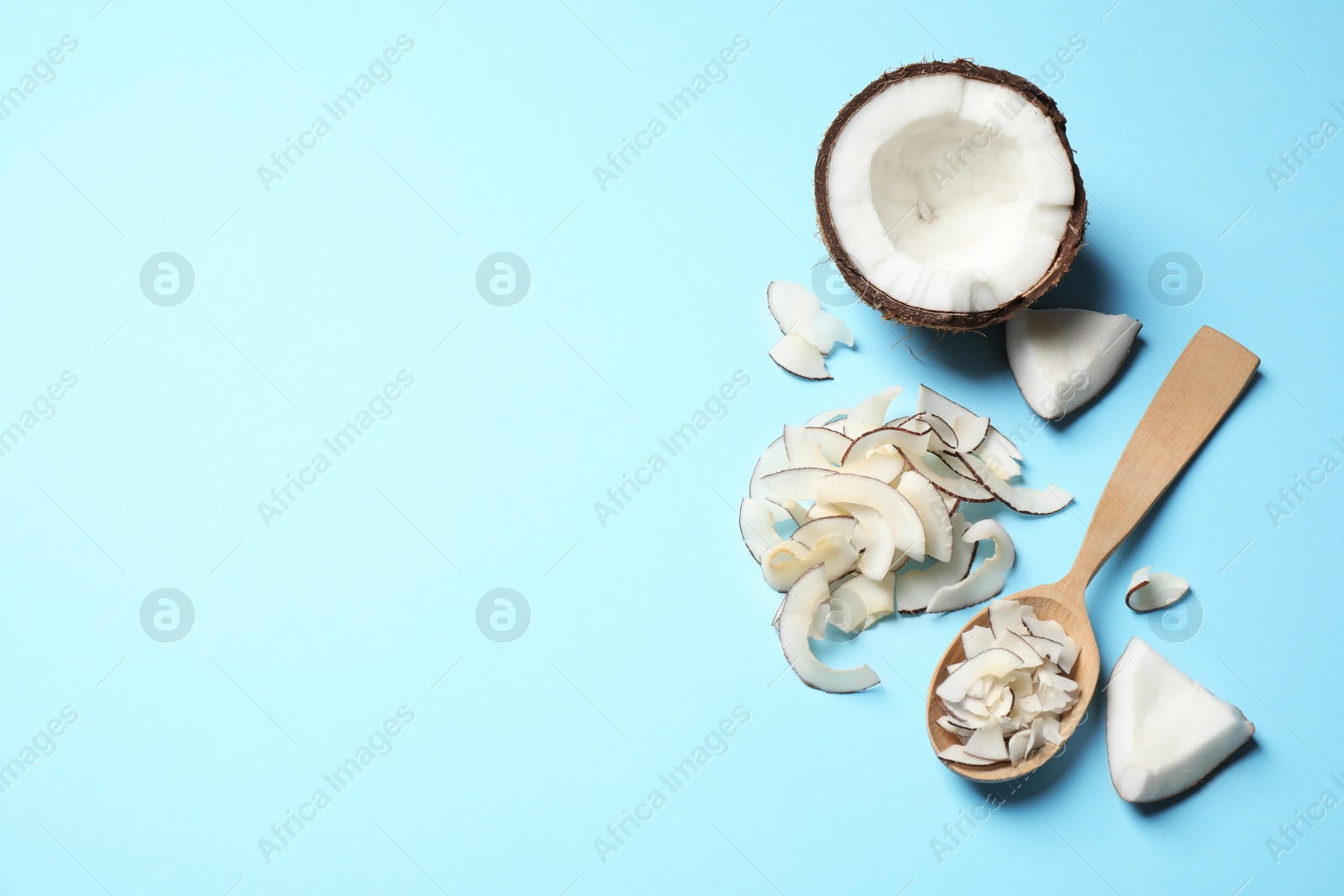 Photo of Flat lay composition with tasty coconut chips on light blue background. Space for text