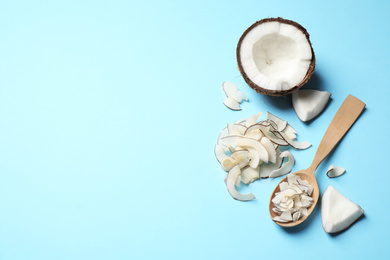 Flat lay composition with tasty coconut chips on light blue background. Space for text