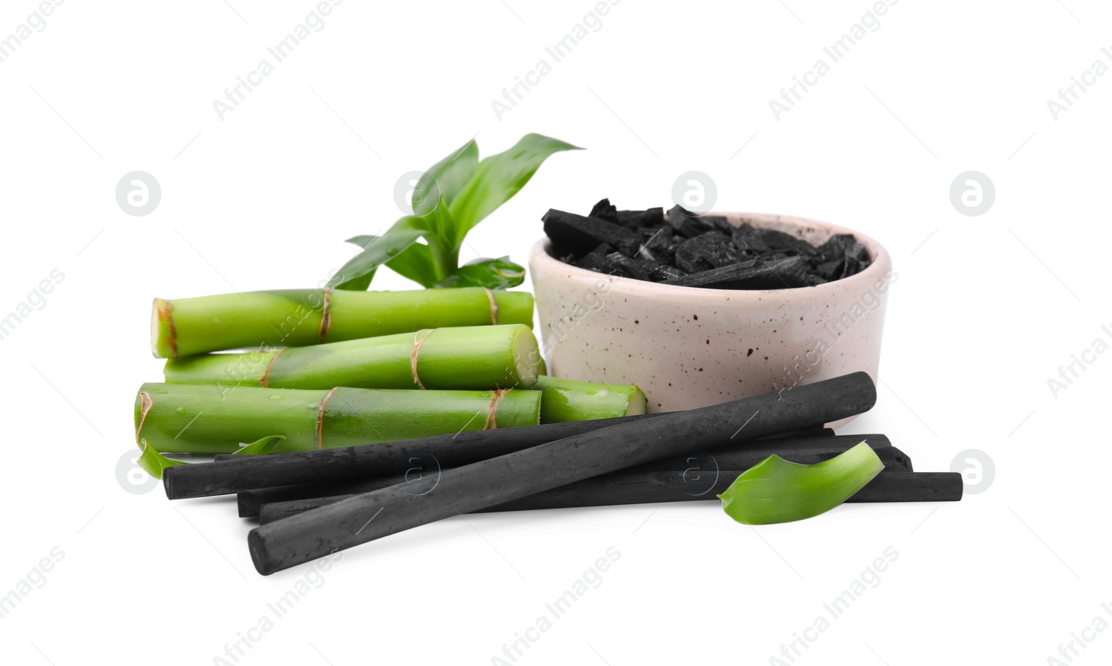 Photo of Fresh bamboo and charcoal on white background