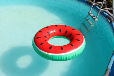 Photo of Inflatable ring floating on water in above ground swimming pool outdoors