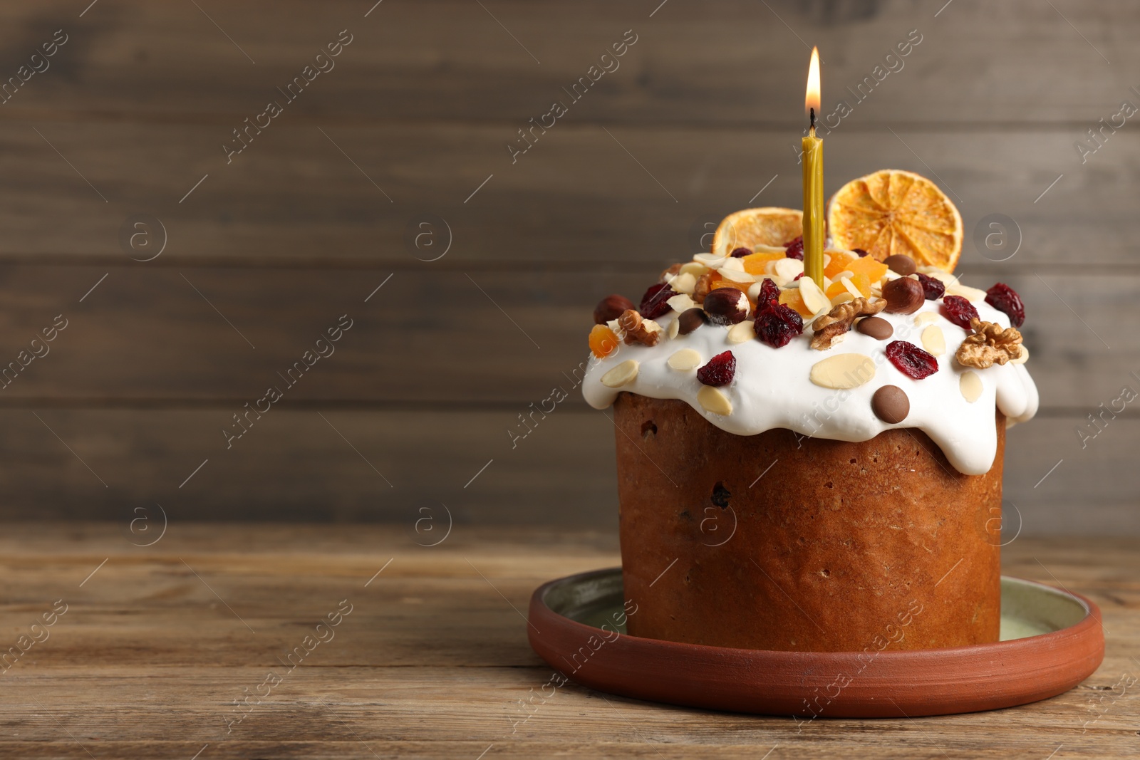 Photo of Tasty Easter cake with dried fruits and nuts on wooden table. Space for text