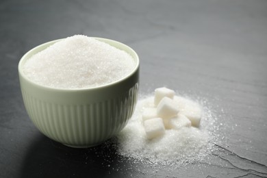 Granulated sugar in bowl on dark table