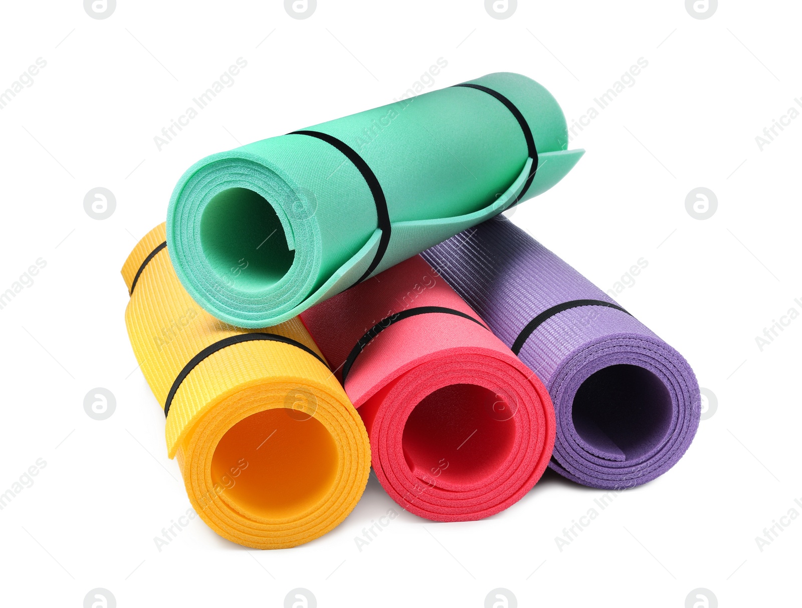 Photo of Colorful rolled camping or exercise mats on white background