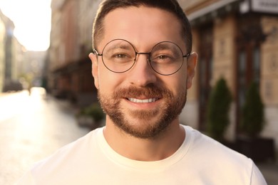 Photo of Portrait of handsome bearded man in glasses outdoors