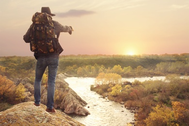 Photo of Man enjoying beautiful nature near mountain river, back view