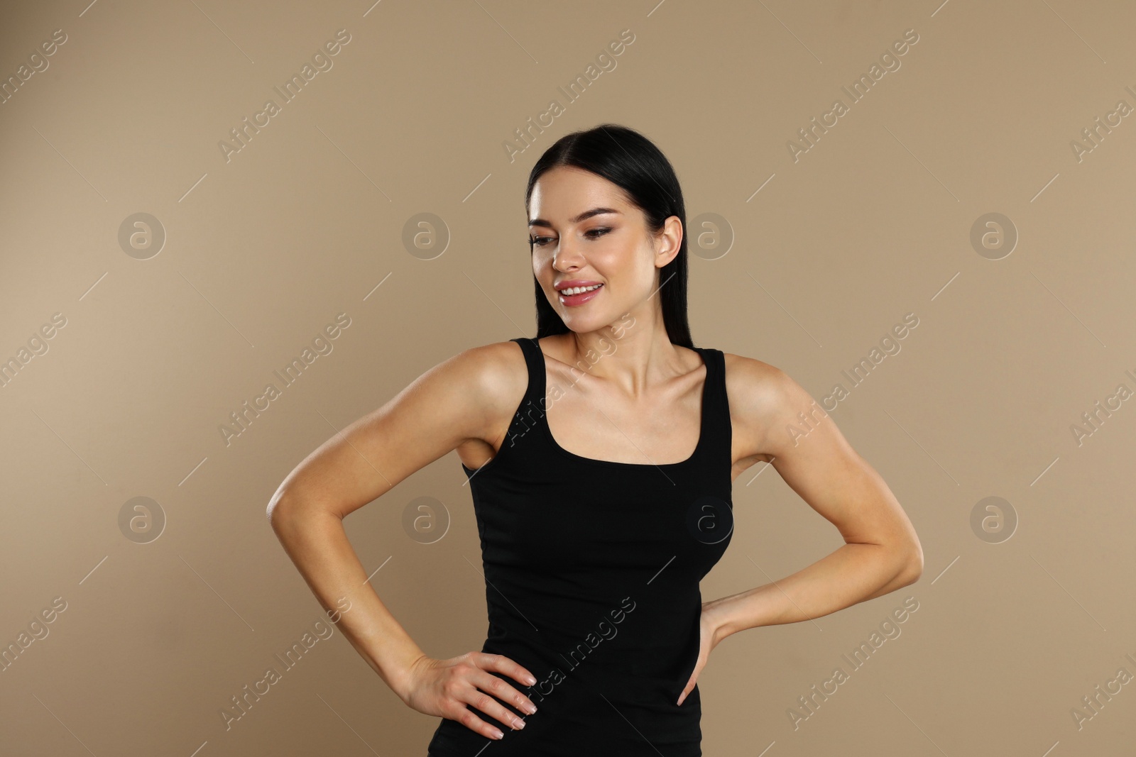 Photo of Beautiful young woman in black underwear on beige background