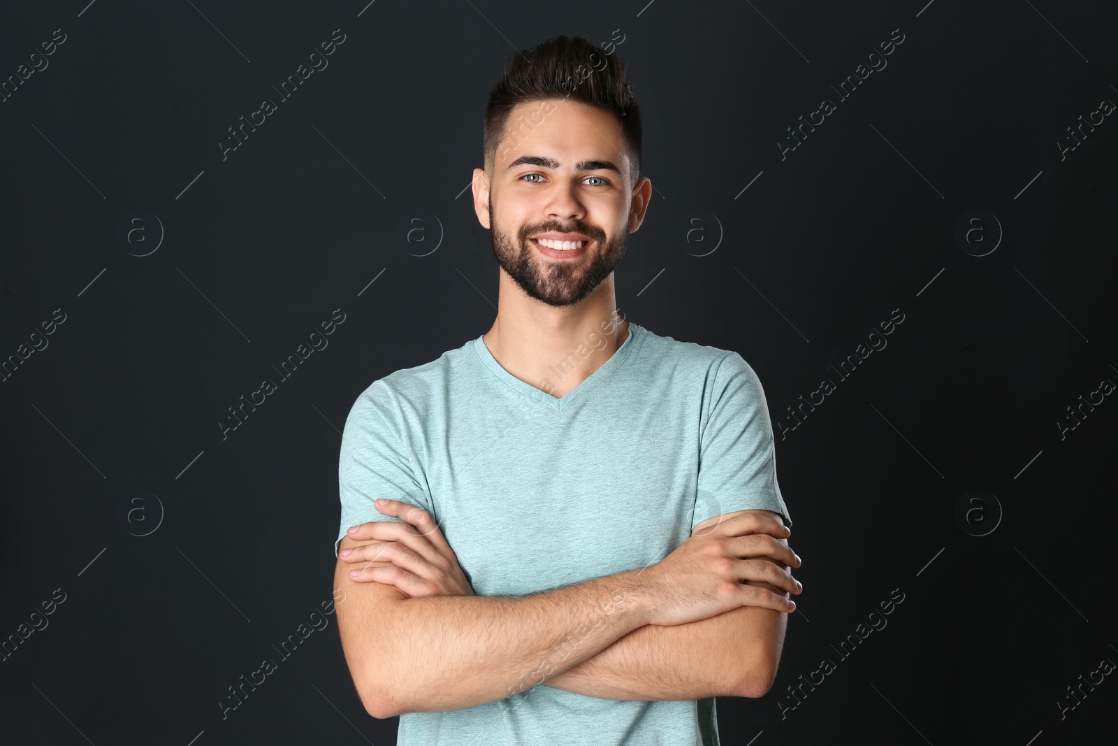 Photo of Portrait of handsome smiling man on black background