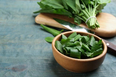 Photo of Fresh green sorrel leaves on light blue wooden table, closeup
