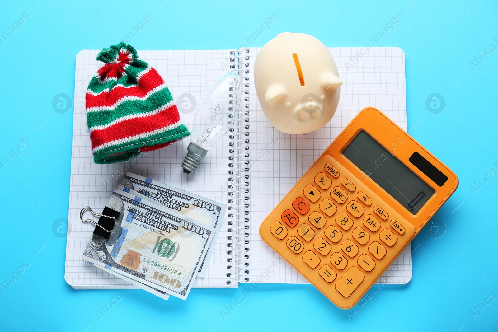 Photo of Flat lay composition with piggy bank and calculator on light blue background. Paying bills concept