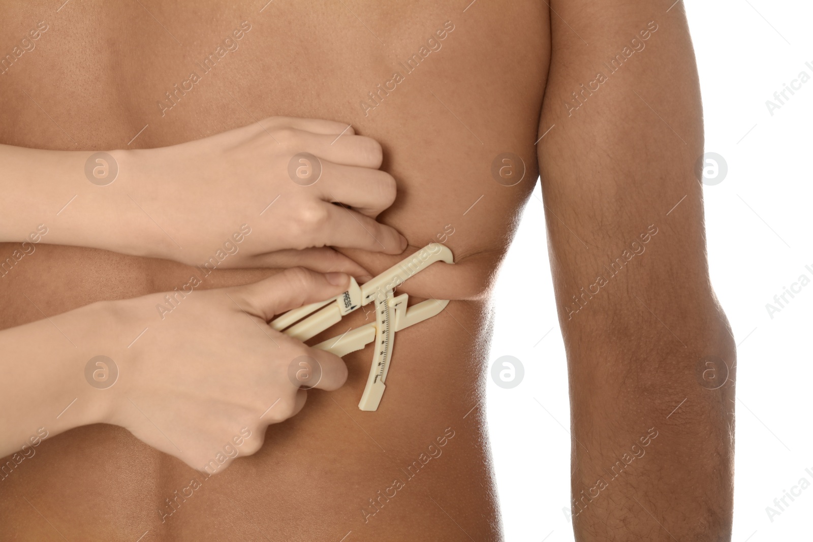 Photo of Nutritionist measuring man's body fat layer with caliper on white background, closeup