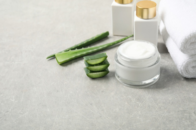 Photo of Different cosmetic products, towels and aloe on grey table