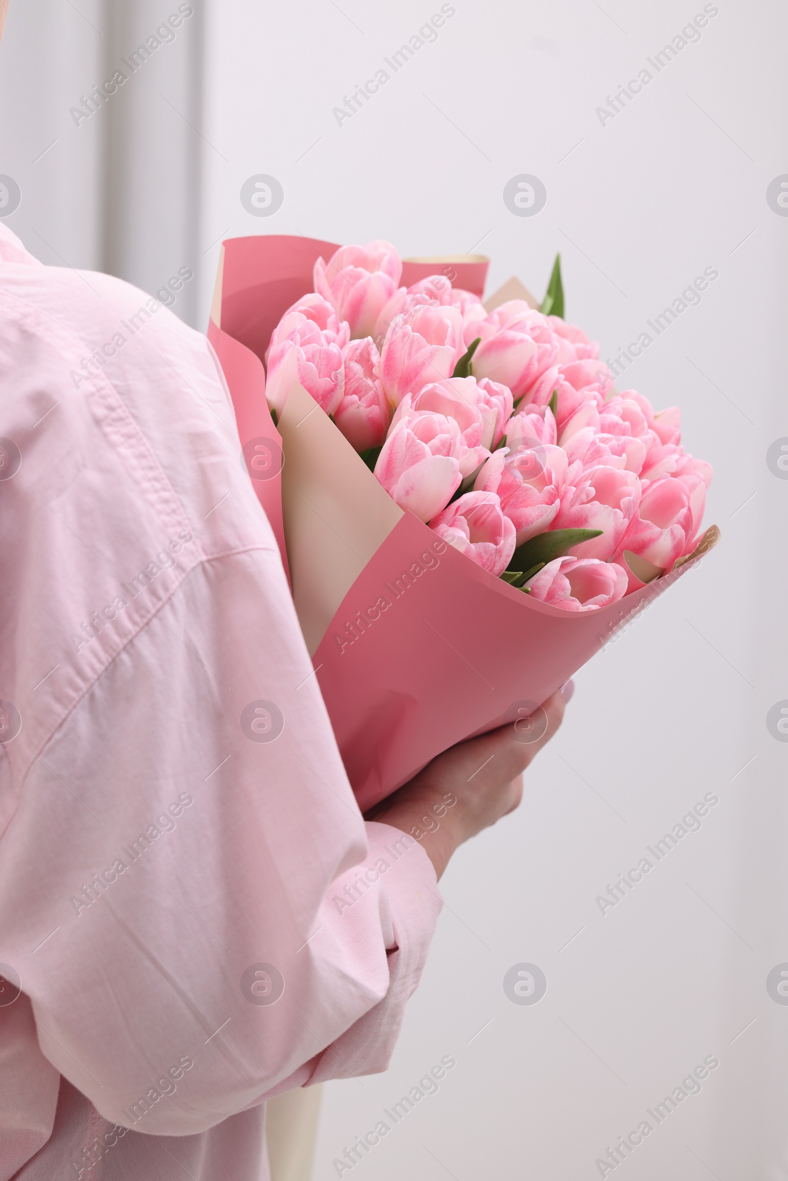 Photo of Woman with bouquet of beautiful fresh tulips on blurred background, closeup