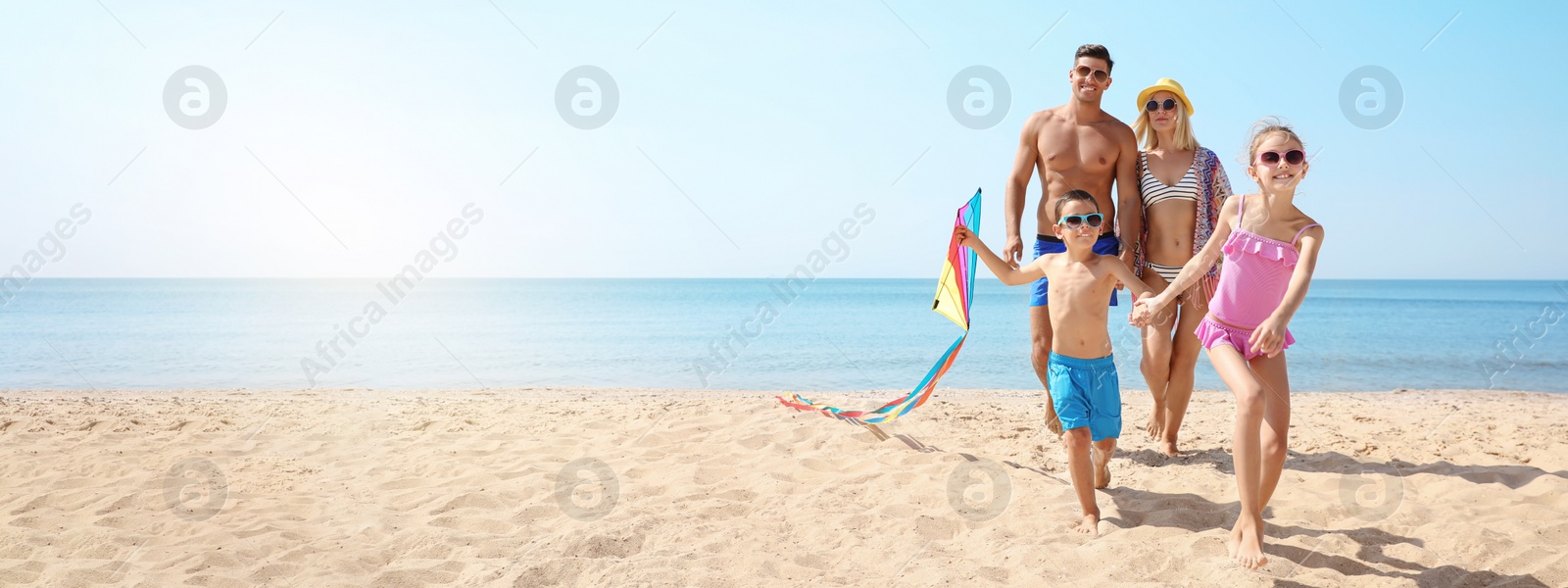 Image of Happy family with kite at beach on sunny day, space for text. Banner design