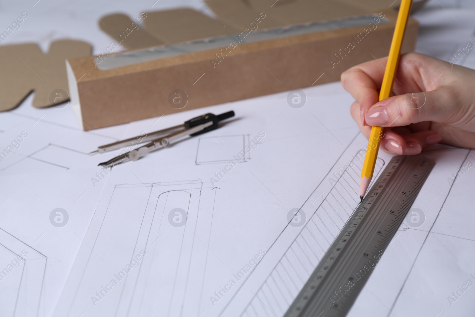 Photo of Woman creating packaging design on paper, closeup