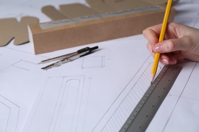 Photo of Woman creating packaging design on paper, closeup