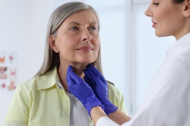 Photo of Endocrinologist examining thyroid gland of patient at hospital