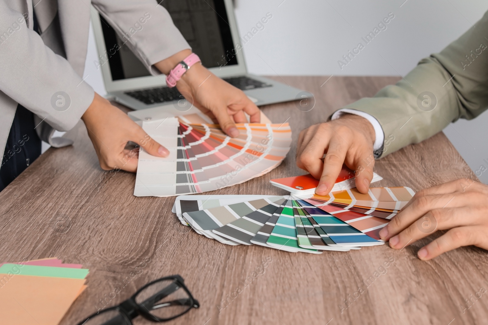 Photo of Team of designers working with color palettes at office table, closeup