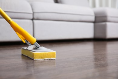 Washing of parquet floor with mop indoors, closeup. Space for text