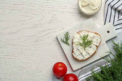 Toasted bread with cream cheese and dill on white wooden table, flat lay. Space for text