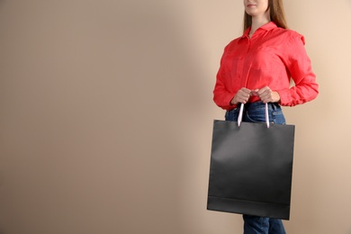 Woman holding paper shopping bag on color background. Mock up for design